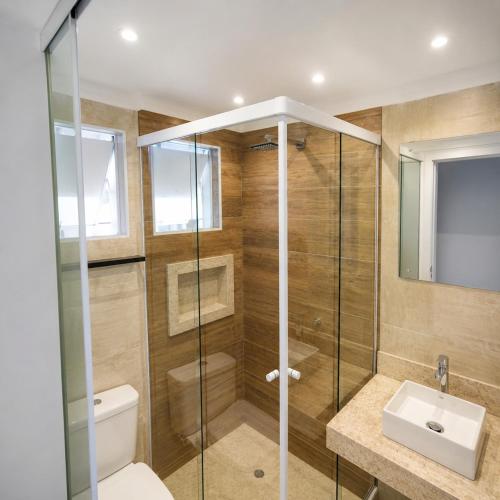 a bathroom with a shower and a toilet and a sink at Paúba Beach Hotel in Pauba