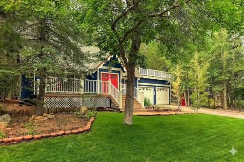 a blue house with a red door and a yard at Serenity Woods - Game Room & More in South Lake Tahoe