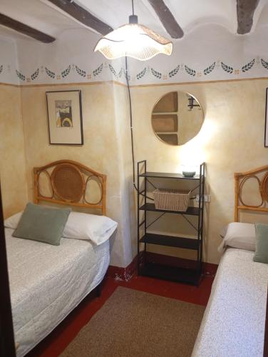 a small room with two beds and a mirror at Torreta de Sant Tomàs in Cocentaina