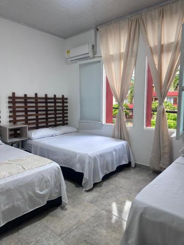 a bedroom with two beds and a window at Hotel San Luis in Buga