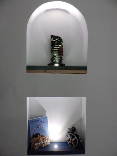 a shelf with a fish statue and a box on it at Timbuktu Hostel in San Vito lo Capo