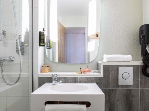 a bathroom with a sink and a mirror at ibis Paris Gennevilliers in Gennevilliers
