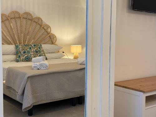 a bedroom with a bed with a headboard and towels at Petra Lavea in Pompei