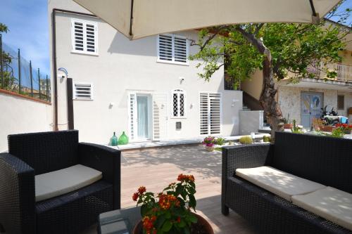 a patio with two chairs and a table and an umbrella at Petra Lavea in Pompei