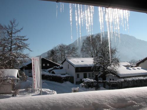 a bunch of icicles hanging from a window with snow at Hotel-Restaurant Zum Hirschhaus Inklusiv Chiemgaukarte in Ruhpolding