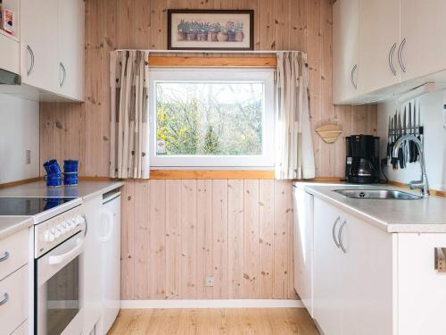 a kitchen with white cabinets and a window at 6 person holiday home in Tarm in Tarm