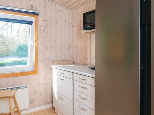 a kitchen with white cabinets and a window at 6 person holiday home in Tarm in Tarm