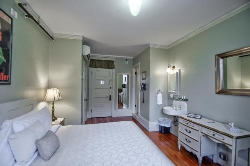 a bedroom with a white bed and a sink at The Peak at Centralia Square - Self Check-In Hotel in Centralia