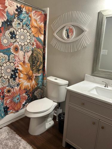 a bathroom with a toilet and a shower curtain at Boho Chic Lovely Garden Home in Spring