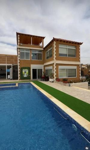 a house with a swimming pool in front of a house at مزرعة اننتارا in Amman