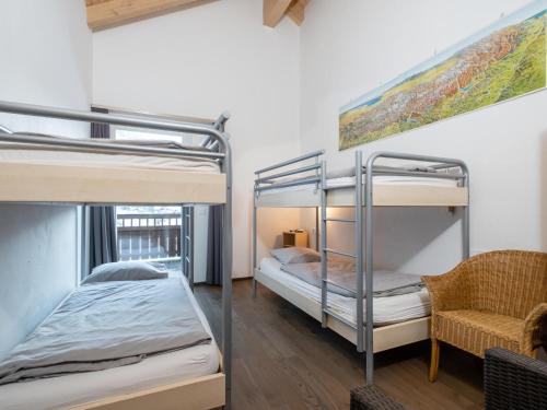 two bunk beds in a room with a chair at Saalbach Hinterglemm in Viehhofen