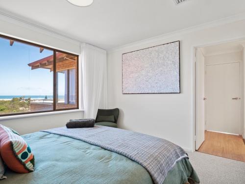 a bedroom with a bed and a large window at Ocean Reef Marina by the Sea 4BR plus Study plus in Perth