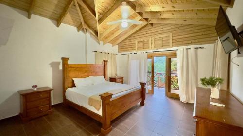 a bedroom with a bed and a ceiling fan at Villa Ana Rosa in Jarabacoa