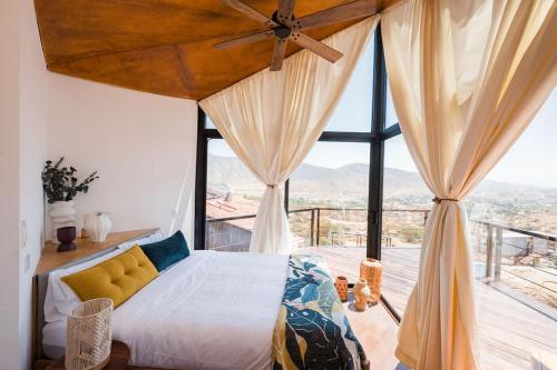 a bedroom with a bed and a large window at Primario Hotel Boutique in Ensenada