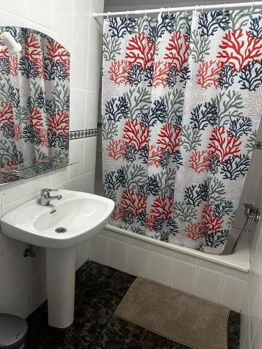 a bathroom with a sink and a shower curtain at Casa La Alpispa in Frontera
