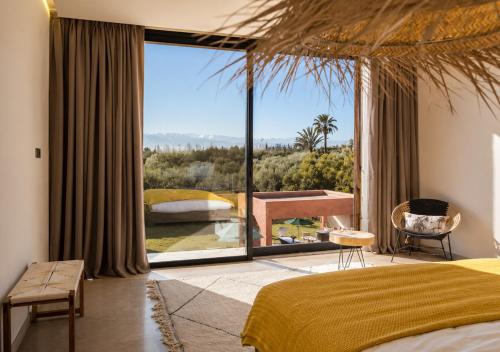 a bedroom with a bed and a large window at Villa Émeraude 5 Ch in Marrakesh