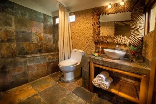 a bathroom with a toilet and a sink at Casa Caribe Hotel in Río Dulce
