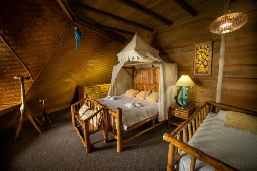 a bedroom with a bed in a log cabin at Casa Caribe Hotel in Río Dulce