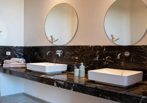 two sinks in a bathroom with two mirrors at Villa Émeraude 5 Ch in Marrakesh