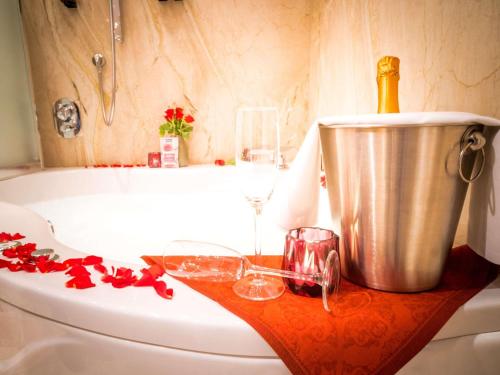a bath tub with a bucket and a bottle of champagne at Mercure Hotel Riesa Dresden Elbland in Riesa