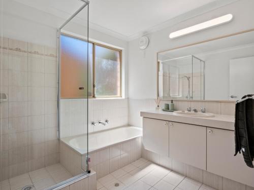 a bathroom with a shower and a tub and a sink at Ocean Reef Marina by the Sea 4BR plus Study plus in Perth