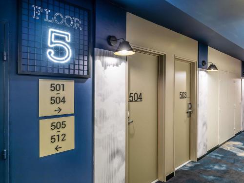 a row of elevators with a sign on a wall at Hotel ibis Lisboa Saldanha in Lisbon