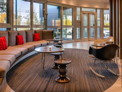 a lobby with a couch and tables and windows at ibis Mendoza in Mendoza