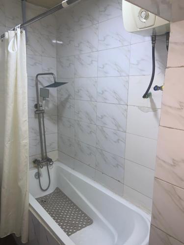 a bathroom with a tub and a shower curtain at Trendy Inn limited in Lagos