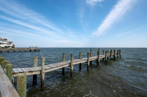 a wooden pier in the water near a house at Serenity Now in Greenbackville