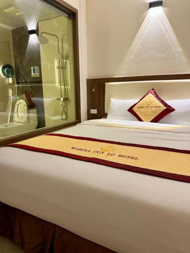 a hotel room with a bed with a sign on it at Marina Cua Lo Hotel in Cửa Lô