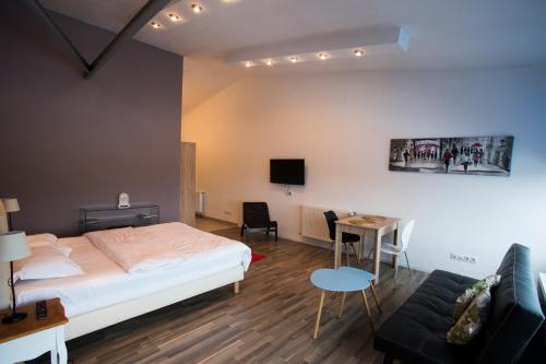 ブカレストにあるHeights Accommodation Unirii Free Parking Zoneのベッドルーム1室(ベッド1台、テーブル、ソファ付)