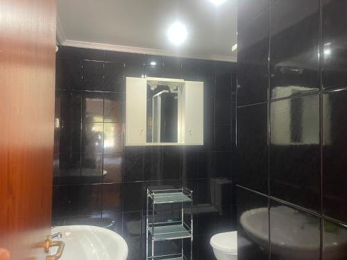 a bathroom with a sink and a toilet and a mirror at Casa do Pai in Vila Praia de Âncora