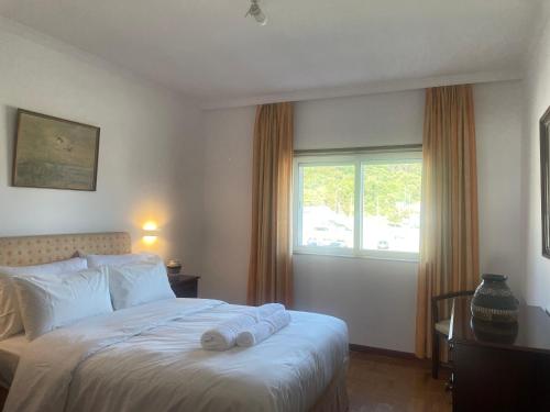 a bedroom with a bed with pillows and a window at Casa do Pai in Vila Praia de Âncora