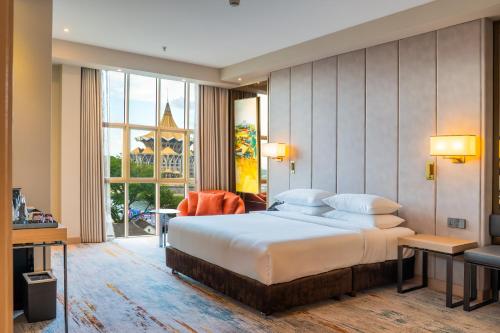 a bedroom with a large bed and a large window at The Waterfront Hotel Kuching in Kuching