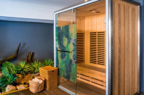 a shower with a glass door in a room at The Waterfront Hotel Kuching in Kuching
