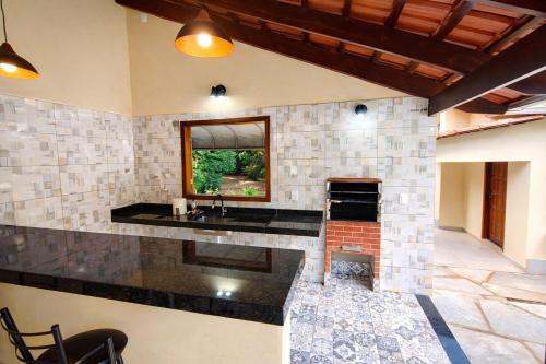 a large kitchen with a sink and a fireplace at Chalé Veredas e Buritis in Pirenópolis