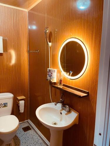 a bathroom with a sink and a mirror and a toilet at Bugalow Tiên Sa Cô Tô in Nam Cap
