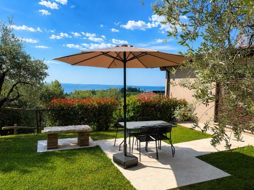 a table and a bench with an umbrella at La Casetta in Toscolano Maderno