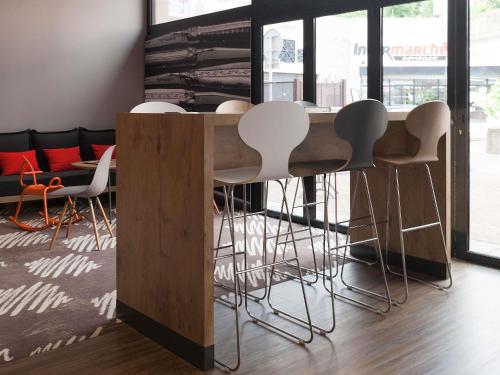 a kitchen with a wooden table and stools at ibis Rodez Centre in Rodez