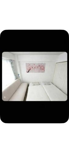 a small bed in a room with a window at エルビスコート井尻101号 in Morooka