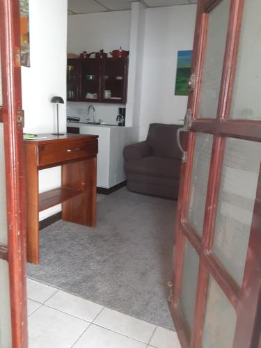 a living room with a desk and a kitchen at Apartamento Vita in Managua
