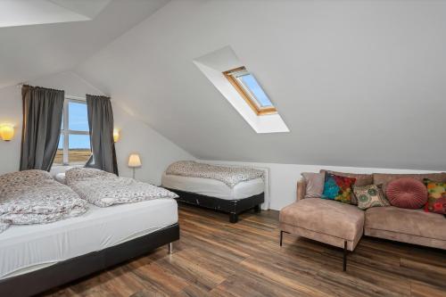 a bedroom with two beds and a couch at Myrarkot Country Home in Selfoss