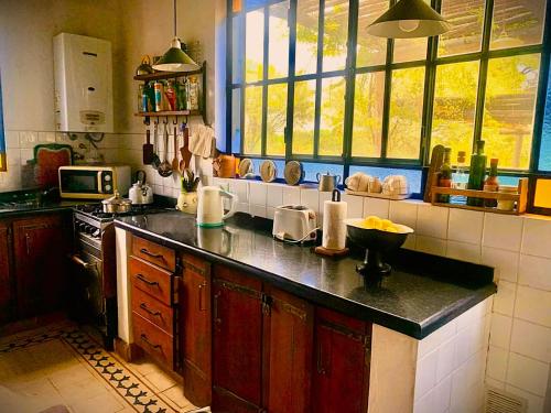 a kitchen with a counter top and some windows at Refugio Serrano con Chimenea y Caballos in San Javier