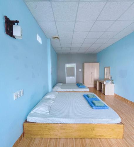 a bedroom with a large bed in a blue room at Bot Bien Homestay in Mui Ne