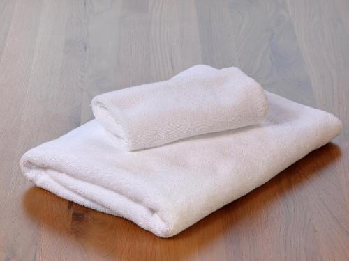 a stack of white towels sitting on a wooden floor at tonaResort Furano in Furano