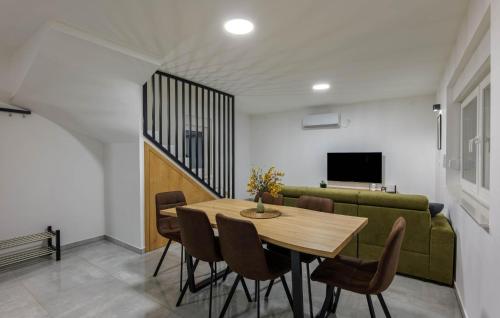 a dining room with a table and a green couch at Amazing Home In Banfi in Štrigova