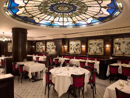 a dining room with tables and a stained glass ceiling at Le Diwan Hotel Rabat - MGallery Collection in Rabat