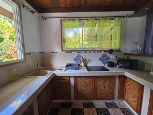 a kitchen with two sinks and a window at Villa Fareatai in Ataiti