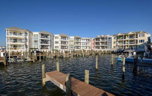 a dock in the water in front of some apartment buildings at Sunset Bay Villa 110 - Hawks Nest in Chincoteague