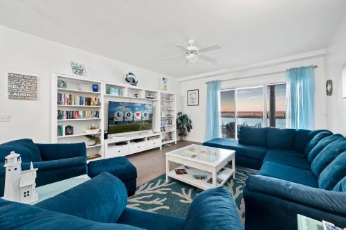 a living room with blue couches and a tv at Sunset Bay Villa 209 in Chincoteague